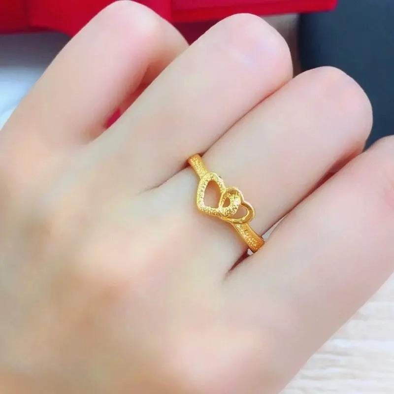 Elegant gold heart-shaped ring worn on a finger