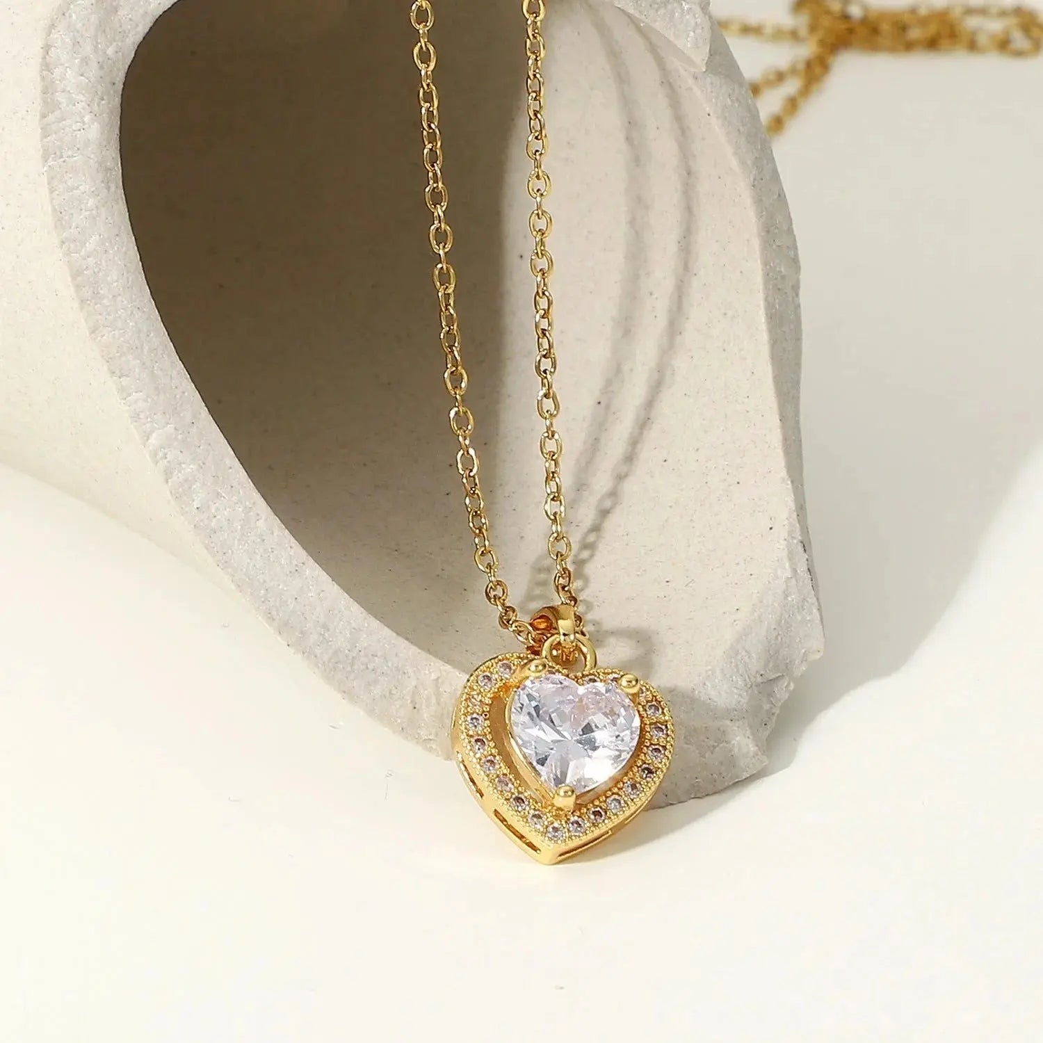 Gold heart-shaped pendant necklace with sparkling cubic zirconia stones.