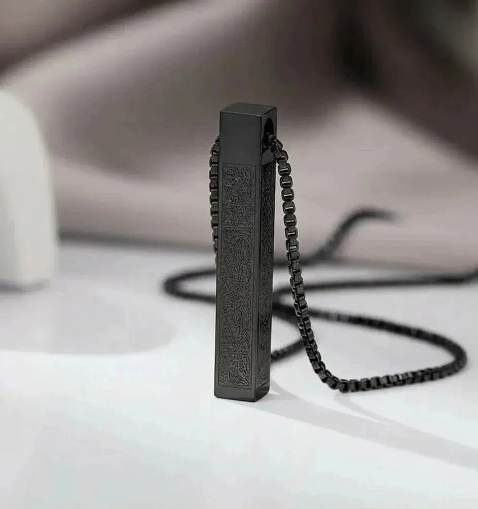 Elegant matte black rectangular pendant necklace with intricate engraved patterns.