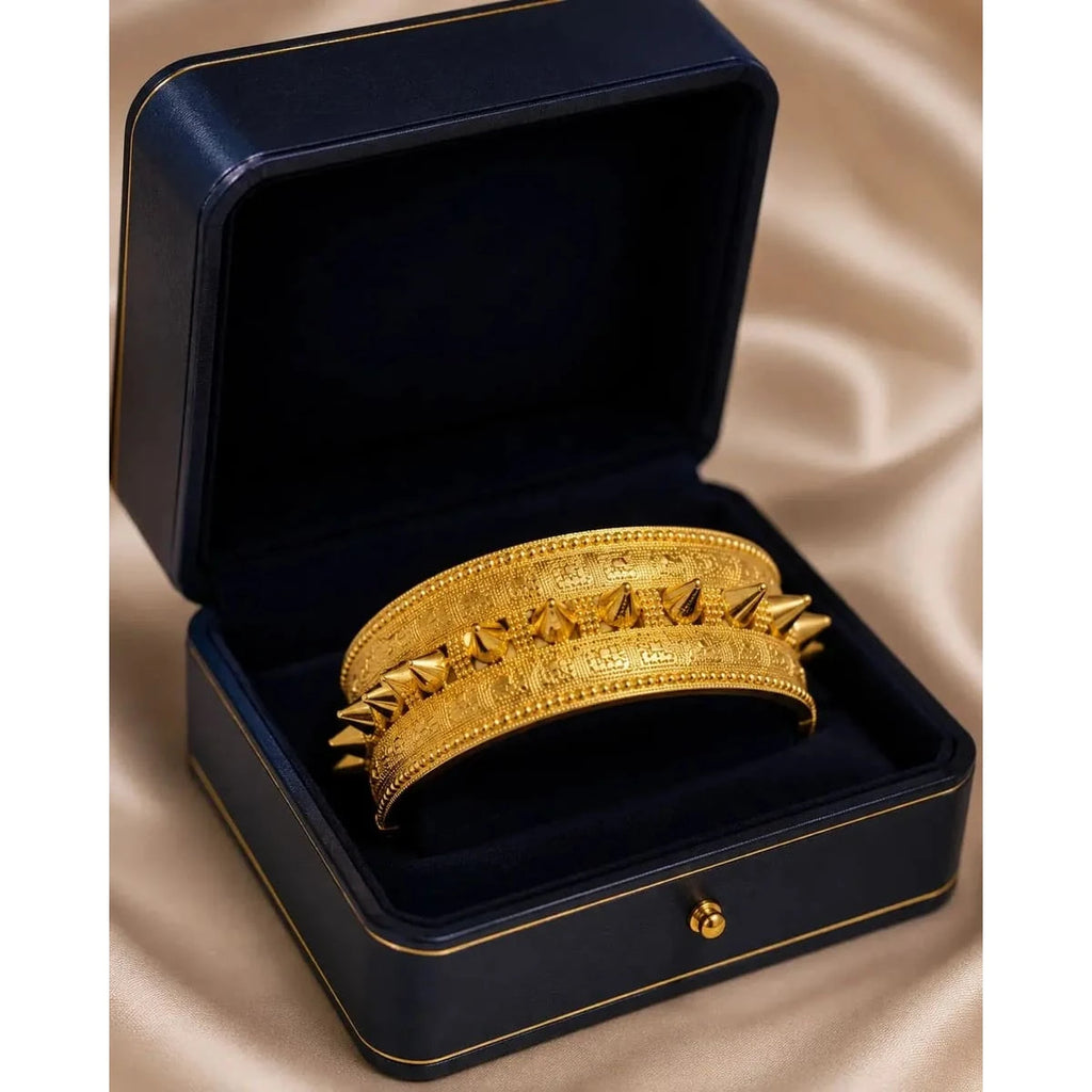 Elegant gold bangle by HAFIZ AND CO, showcasing a sleek, smooth design with a polished finish on a white background.