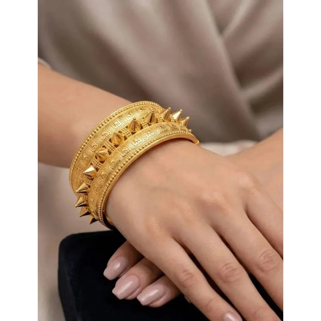 Shiny gold bangle from HAFIZ AND CO with an elegant, smooth design, showcasing a luxurious accessory for women.