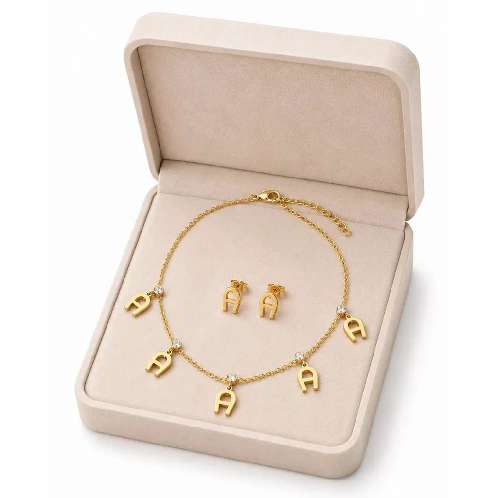 Elegant gold necklace from HAFIZ AND CO featuring intricate design and polished finish, displayed on a neutral background.
