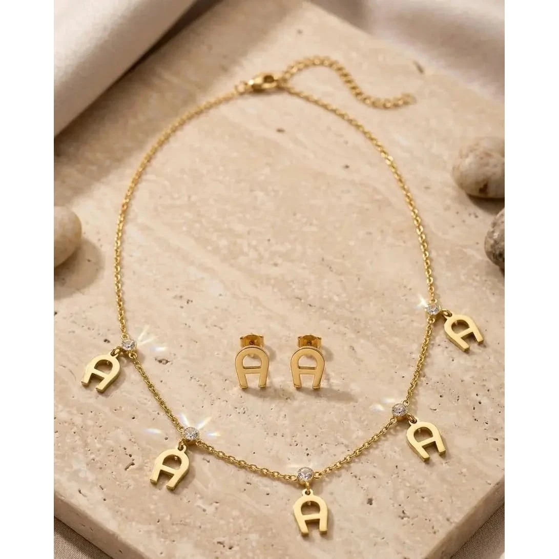 Elegant gold necklace from HAFIZ AND CO featuring intricate design and polished finish, displayed against a neutral background.