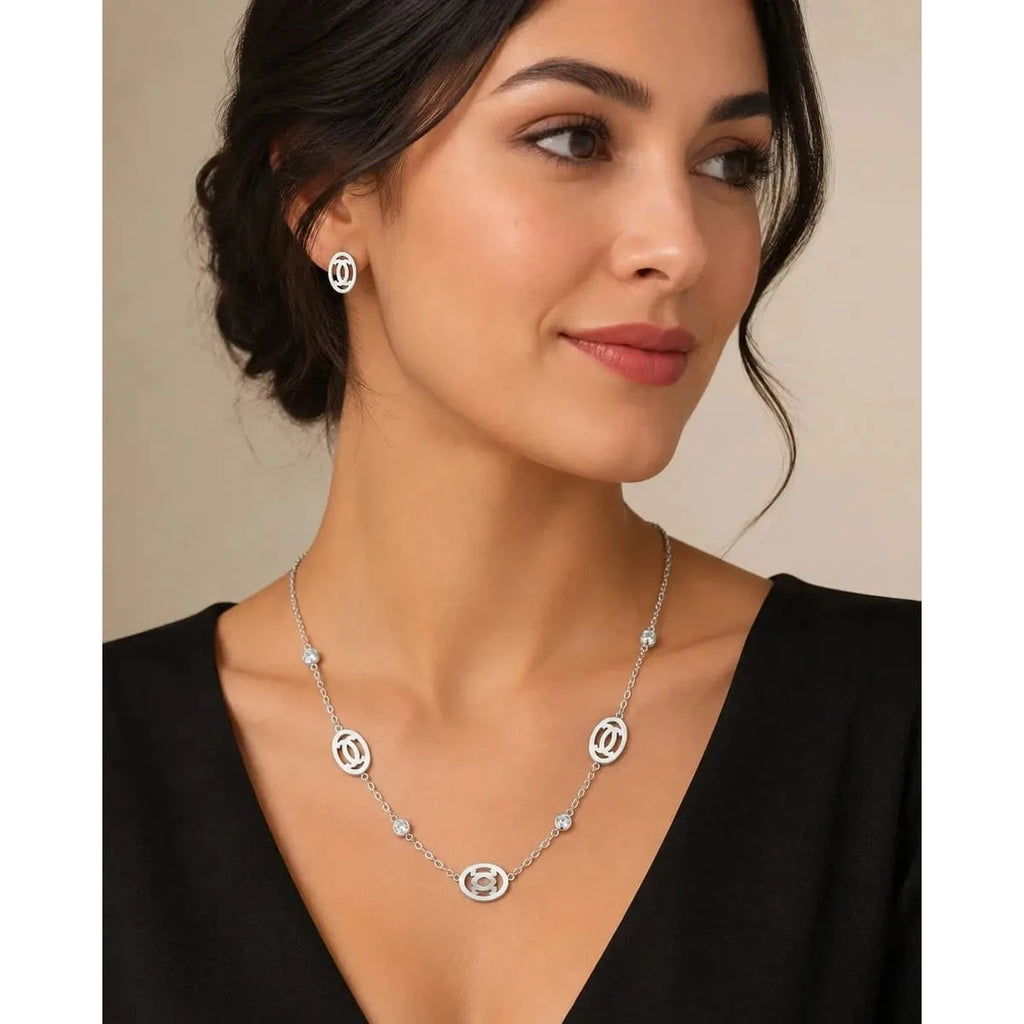 Silver jewelry set with matching necklace and stud earrings by HAFIZ AND CO, featuring elegant design and polished silver finish.