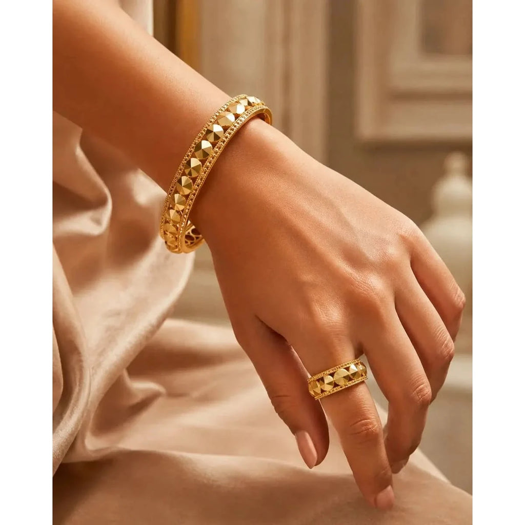 Studded gold bangle set by HAFIZ AND CO l featuring multiple bangles with textured and studded designs on a neutral background.