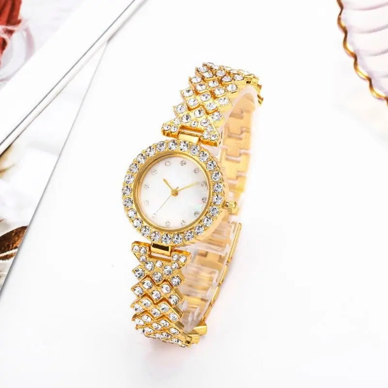 Gold women's quartz watch by Zambeel with diamond accents and alloy band, featuring a sleek, elegant design.